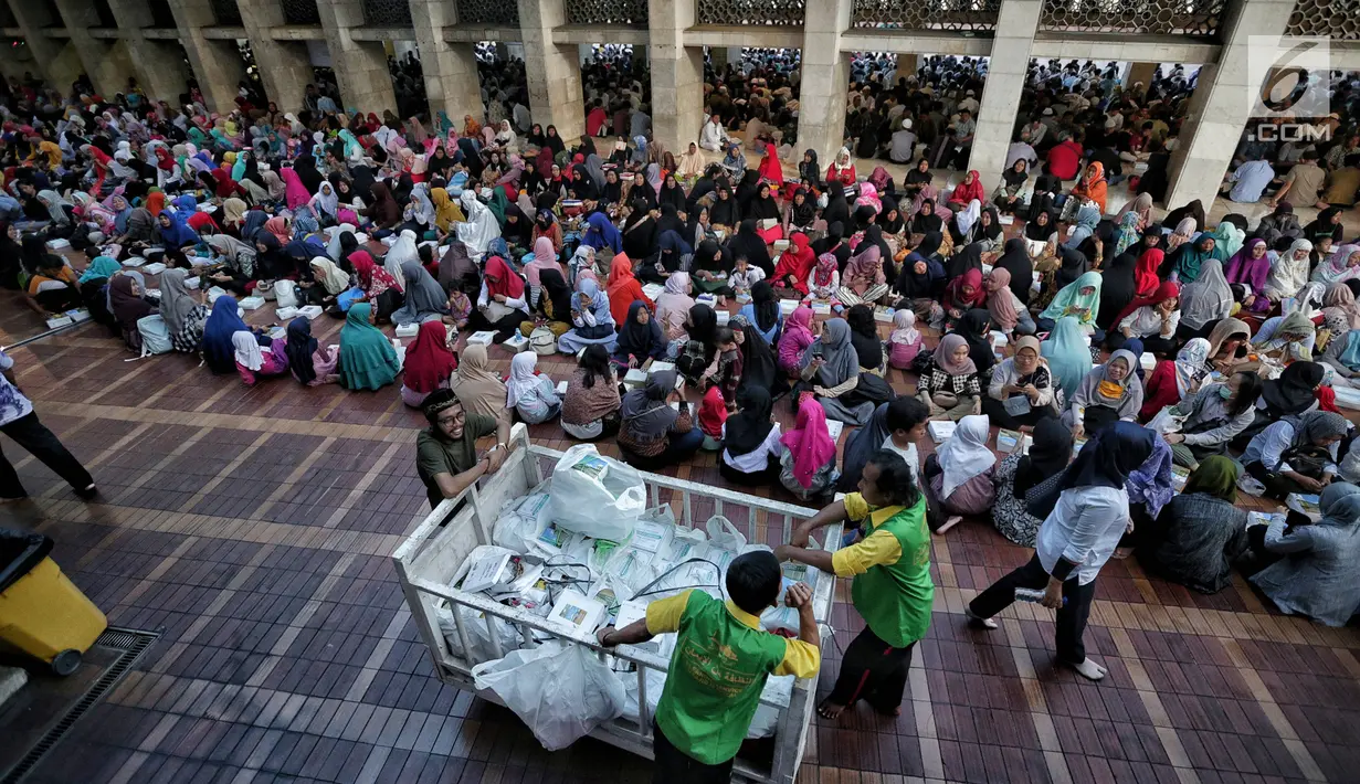 Panitia membagikan nasi kotak jelang buka puasa bersama di Masjid Istiqlal, Jakarta, Senin (6/5/2019). Umat muslim yang ingin mengikuti buka puasa bersama sudah berdatangan sejak sore hari. (Liputan6.com/Faizal Fanani)