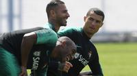 Ekspresi Cristiano Ronaldo (kanan) saat pemanasan dengan Ricardo Quaresma dan Ricardo Pereira (kiri) pada sesi latihan di Kratovo, Moskow, (12/6/2018). Portugal akan mejalani laga perdana grup B melawan Spanyol. (AFP/Francisco Leong)