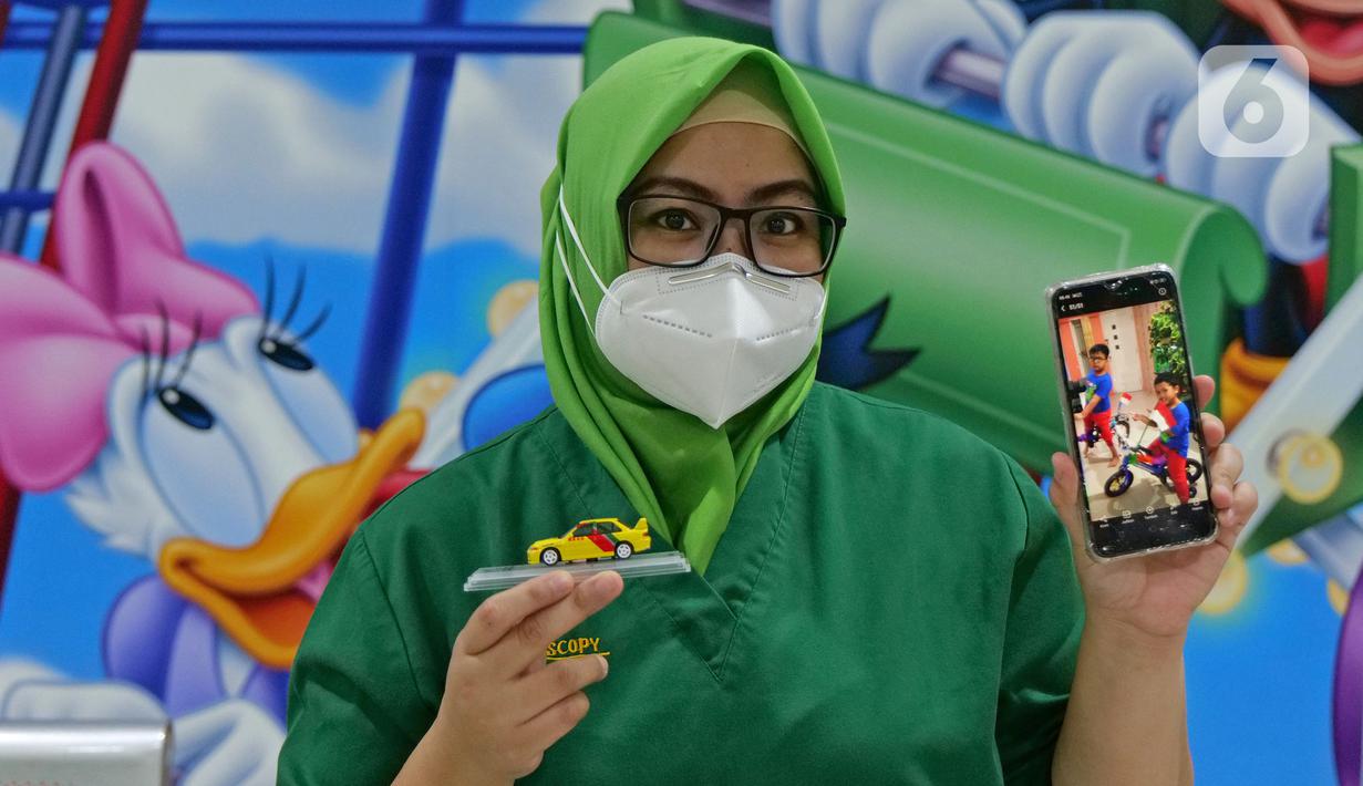 Perawat Irma Afrianti (34) menunjukkan foto anaknya saat di RSUD Pasar Minggu, Jakarta, Jumat (22/5/2020). Irma Afrianti sudah 2 bulan tidak bertemu keluarga selama bertugas menjaga COVID -19 di RSUD Pasar Minggu. (Liputan6.com/Herman Zakharia)