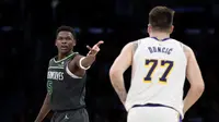 Anthony Edwards dari Timberwolves melakukan selebrasi di depan pemain Lakers Luka Doncic di laga pertama playoff NBA 2025 (AFP)