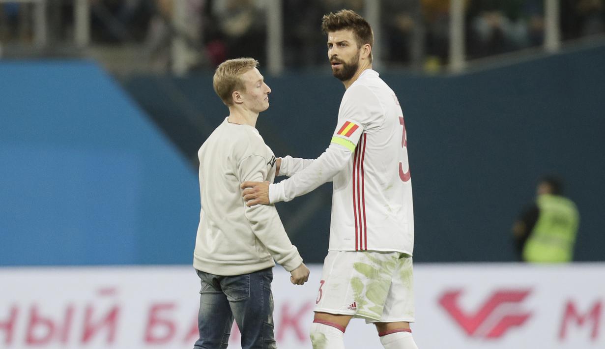 Seorang suporter memasuki lapangan dan menghampiri Gerard Pique saat Spanyol melawan Rusia pada laga persahabatan di St.Petersburg, Russia, (14/11/2017). Spanyol bermain imbang 3-3 lawan Rusia. (AP/Dmitri Lovetsky)