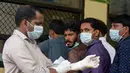 Paramedis dan warga menggunakan masker untuk mencegah penularan virus Nipah di RS Government Medical College Kozhikode, Kerala, India Selatan, Kamis (24/5). Nipah adalah infeksi yang dapat ditularkan ke manusia dari hewan. (AP Photo)