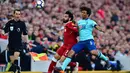 Pemain Bournemouth Nathan Ake berusaha menghadang pemain Liverpool Mohamed Salah saat pertandingan Liga Inggris di Anfield, Liverpool (14/4). Liverpool meraih kemenangan telak pada laga kandang melawan Bournemouth. (Anthony Devlin/PA via AP)