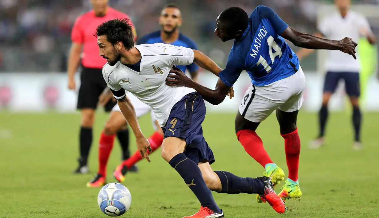 Bek Italia, Davide Astori, berusaha melewati gelandang Prancis, Blaise Matuidi. Pada laga ini Italia menggunakan formasi 3-5-2, sementara Prancis menggunakan skema 4-3-3. (EPA/Tony Vece)