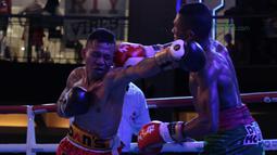 Frans Damur (kiri) dan Jon Jon Jet saling melepaskan pukulan pada kelas Flyweight Mahkota Boxing Super Series di Cilandak Town Square, Jakarta (10/3/2018). Jon Jon Jetz menang angka mutalak atas Frans. (Bola.com/Nick Hanoatubun)
