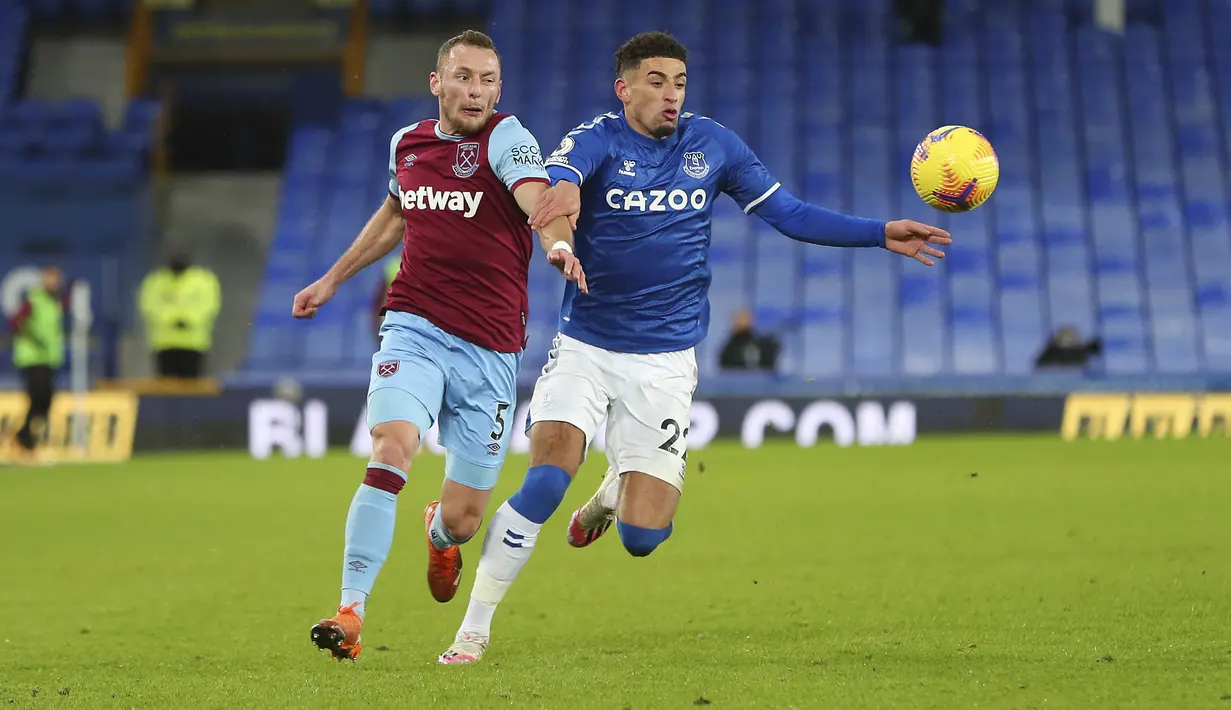Pemain Everton, Ben Godfrey berebut bola dengan pemain West Ham Vladimir Coufal pada pertandingan lanjutan Liga Inggris di Goodison Park, Sabtu (2/1/2021). (Peter Byrne,Pool via AP)