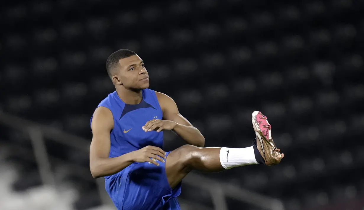 Penyerang Prancis, Kylian Mbappe melakukan peregangan selama sesi latihan di Doha, Qatar, Jumat, 25 November 2022.  Prancis telah mengawali langkah dengan gemilang. Di laga pertamanya, sang juara bertahan menang 4-1 atas Australia. Sementara itu, Denmark hanya mampu bermain imbang 0-0 dengan Tunisia. (AP Photo/Christophe Ena)