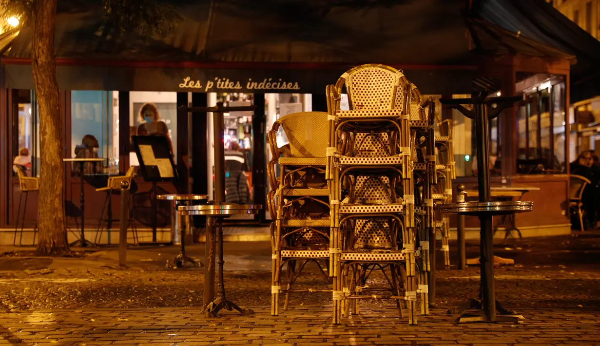 Tumpukan kursi di teras bar yang tutup di Paris di tengah langkah-langkah baru untuk memerangi penyebaran cepat Covid-19 pada Senin (5/10/2020). Seluruh bar dan kafe di Paris – yang diberlakukan siaga maksimum Covid-19 – ditutup selama dua pekan, yang dimulai 6 Oktober. (GEOFFROY VAN DER HASSELT/AFP