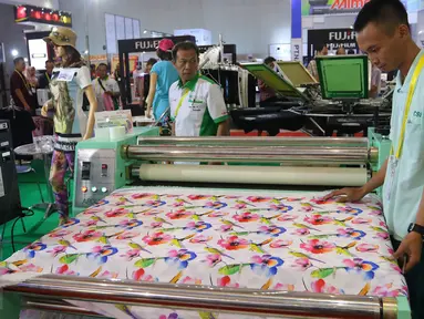 Petugas memperlihatkan hasil print satu produk saat Pameran Mesin Cetak dan Print All Pack Indonesia, All Process di Jakarta International Expo, Kemayoran, Jakarta, Rabu (5/10). (Liputan6.com/Angga Yuniar)