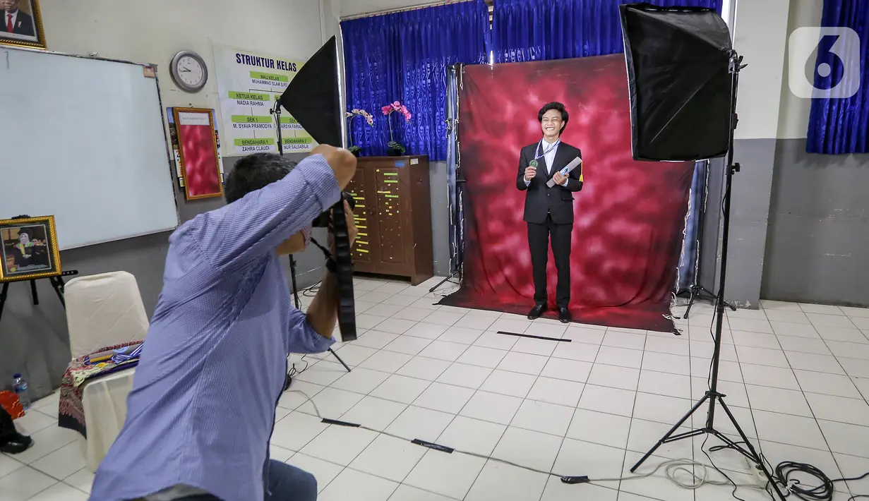 Siswa sedang foto kelulusan pada acara Wisuda Pelepasan Kelas XII di Madrasah Aliyah Annajah, Petukangan, Jakarta, Kamis (18/6/2020). Sebanyak 85 siswa mengikuti Wisuda Drive Thru untuk menghindari kerumunan dan sebagai upaya mencegah penyebaran virus Covid-19. (Liputan6.com/Fery Pradolo)