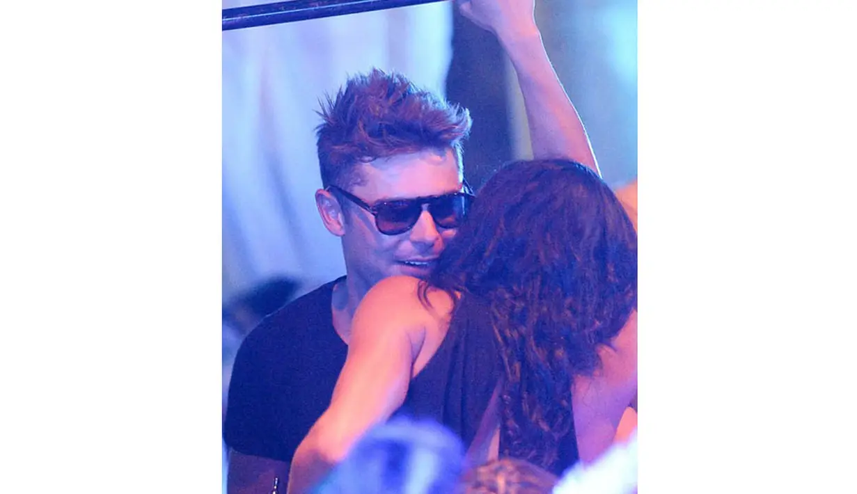Zac Efron terlihat berbisik mesra pada kekasihnya, Michelle Rodriguez di sebuah club, Billionaire Porto Cervo, Sardinia, Italia. (9/7/14) (TMZ.com)