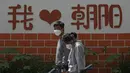 <p>Pejalan kaki yang mengenakan masker berjalan di dekat dinding yang memajang tulisan "I Love Chaoyang" saat akan menjalani tes COVID-19 di distrik Chaoyang, Beijing, Rabu (11/5/2022). Shanghai pada Rabu menegaskan kembali akan mempertahankan pendekatan &ldquo;nol-COVID&rdquo; pengendalian pandemi, sehari setelah kepala Organisasi Kesehatan Dunia (WHO) menyatakan kebijakan itu tidak berkelanjutan dan mendesak China mengubah strategi. (AP Photo/Andy Wong)</p>