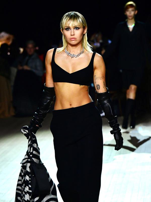Miley Cyrus berjalan di catwalk untuk show Marc Jacobs Fall 2020 selama New York Fashion Week di New York City, Rabu (12/2/2020). Miley Cyrus memancarkan energi rockstar dalam balutan bralette hitam dipadu celana panjang dengan warna senada serta menenteng coat zebra (Slaven Vlasic/Getty Images/AFP)