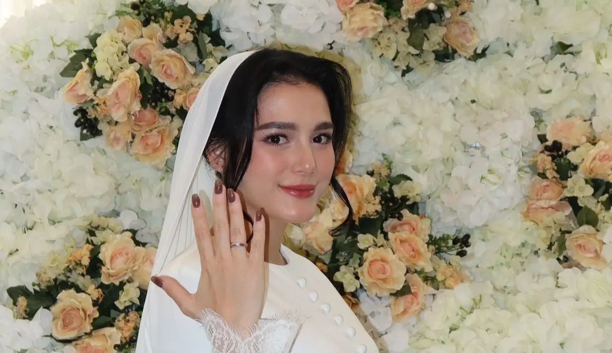 Dalam foto-foto yang dibagikan di Instagram, Yasmine tampak anggun dengan balutan busana bernuansa putih. Senyumnya mengembang saat menerima cincin dari Arifin, yang terlihat penuh kasih dan bahagia. Suasana romantis semakin terasa dengan dekorasi yang hangat, mencerminkan keintiman hubungan mereka yang kian kuat.  (Liputan6.com/IG/@yxsmine.ow)