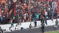 Sejumlah suporter berada di sekitar pagar besi tribun Jakarta International Stadium (JIS) yang rusak di Jakarta, Minggu (24/7/2022). Pagar di sisi utara stadion tingkat dunia tersebut roboh akibat diduduki oleh para penonton. (Liputan6.com/Herman Zakharia)