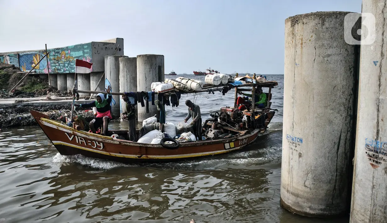 Perahu nelayan melintasi tanggul laut saat tiba di Perkampungan Nelayan Kalibaru, Cilincing, Jakarta Utara, Rabu (29/6/2022). Berdasarkan data Dinas Ketahanan Pangan, Kelautan, dan Pertanian (DKPKP) Provinsi DKI Jakarta, jumlah produksi perikanan tangkap dan budidaya di Ibu Kota pada tahun 2020 masing-masing sebanyak 107.828,84 dan 3.869,48 ton. (merdeka.com/Iqbal S. Nugroho)