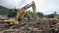 Eskavator memindahkan kayu yang terseret arus di Wasior, Papua Barat. Rehabilitasi pascabanjir Wasior kini difokuskan pada pembersihan serta pembuatan rumah hunian sementara (huntara).(Antara) 