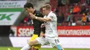 Pemain Borussia Dortmund, Giovanni Reyna, berebut bola dengan pemain Augsburg, Andre Hahn, pada laga Bundesliga, Minggu (27/9/2020). Augsburg menang dengan skor 2-0. (Matthias Balk/dpa via AP)