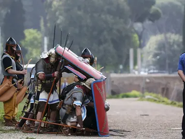 Sejumlah anggota Gruppo Storico Romano (Grup Sejarah Roma) berpakaian perang lengkap dengan tameng dan senjata di Circus Maximus, Roma, Italia , (24/4). Kegiatan ini untuk merayakan ulang tahun berdirinya Roma yang ke-2769. (REUTERS / Alessandro Bianchi)