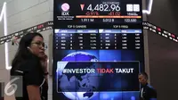 Pengunjung melintas di bawah layar bertuliskan #investor tidak takut di Bursa Efek Indonesia, Jakarta, Senin (18/1). Direktur utama BEI Tito menjelaskan tidak terjadi pengaruh besar pasca teror terhadap perdagangan di BEI. (Liputan6.com/Angga Yuniar)