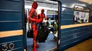 Penari underground yang mengenakan kostum Spiderman membawa tas mereka di kereta bawah tanah Saint Petersburg, pada 21 Mei 2021. Penamplan khusus penari Rusia tersebut membuat sejumlah penumpang yang berada di dalam subway kaget dan terhibur. (Olga MALTSEVA / AFP)