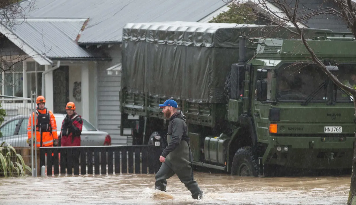Petugas mengevakuasi pemilik rumah di Christchurch, Selandia Baru, Sabtu, (22/7). Banjir yang meluas telah menyebabkan kekacauan terutama di daerah pesisir Pulau Selatan. (AP Photo / Mark Baker)