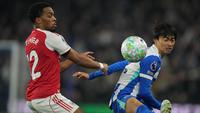 Jurrien Timber dan Kaoru Mitoma berebut bola dalam laga Liga Inggris antara Brighton vs Arsenal di American Express Stadium, 5 Maret 2026. (AP Photo/Alastair Grant)