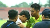 Kurniawan Kartika Ajie memberi semangat Yusuf Meilana yang merasakan sakit di lututnya. (Bola.com/Gatot Sumitro)