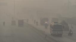 Pengendara kendaraan melintas di tengah kondisi kabut asap di Lahore, Pakistan, Senin (8/11/2021). Lahore menjadi salah satu kota paling tercemar di dunia. (Arif ALI/AFP)