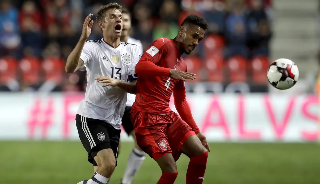 Pemain Jerman, Thomas Müller (kiri) berebut bola dengan pemain Republik Ceska, Theodor Gebre Selassie  pada laga Grup C kualifikasi Piala Dunia 2018 di Plzen, Republik Ceska (1/9/2017). Jerman menang 2-1. (AP/Petr David Josek)