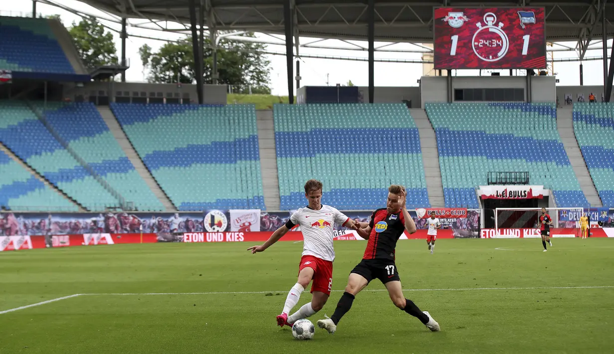 Pemain RB Leipzig, Daniel Carvajal, berebut bola dengan pemain Hertha Berlin, Maximilian Mittelstaedt, pada laga  Bundesliga di Red Bull Arena, Rabu (27/5/2020). Kedua tim bermain imbang 2-2. (AP/Alexander Hassenstein)