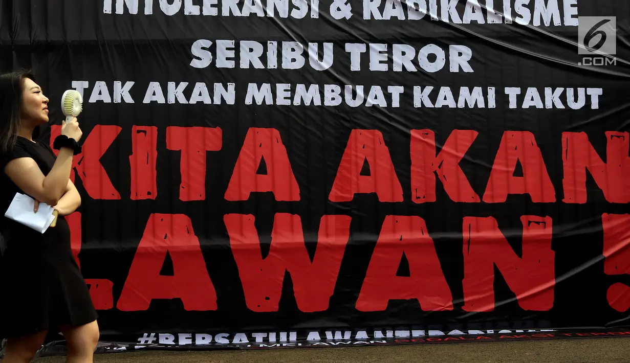 Seorang wanita berdiri di depan poster saat massa dari "Gerakan Rakyat Nusantara Anti Terorisme" atau disingkat "Geranat" melakukan Aksi di depan Gedung MPR/DPR Senayan, Jakarta, Rabu (16/5). (Liputan6.com/JohanTallo)