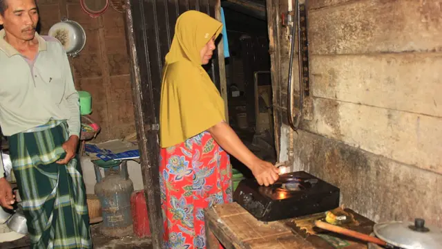 Istri Resmihar ketika menyalakan kompor biogas miliknya. (Liputan6.com/ Ahmad Adirin)