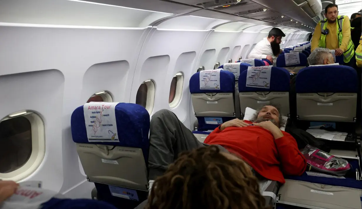 Pengungsi Yahudi Ukraina dan imigran baru dengan kesehatan buruk yang melarikan diri dari perang di negara mereka menunggu untuk turun dari pesawat setibanya di Bandara Ben Gurion, Tel Aviv, Israel, 22 Desember 2022. Sebanyak 100 orang Yahudi Ukraina tiba di Israel, termasuk beberapa penumpang yang terbaring di tempat tidur dan dalam kondisi sakit. (GIL COHEN-MAGEN/AFP)