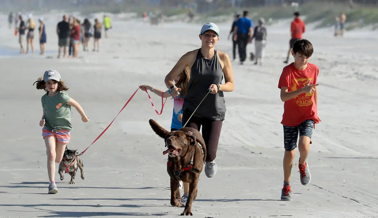 Warga berlari di Jacksonville Beach, Florida (17/4/2020). Pantai dibuka mulai pukul 06.00--11.00 dan pukul 17.00--20.00 setiap hari dengan beberapa batasan, menurut situs web Jacksonville. (Sam Greenwood / Getty Images / AFP)