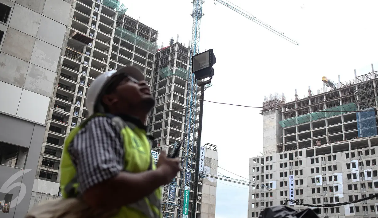 Pekerja memantau pembangunan Kompleks Wisma Atlet Kemayoran, Jakarta, Kamis (29/12). Rusun ini terdiri dari 10 tower dengan jumlah unit 7.424. (Liputan6.com/Faizal Fanani)