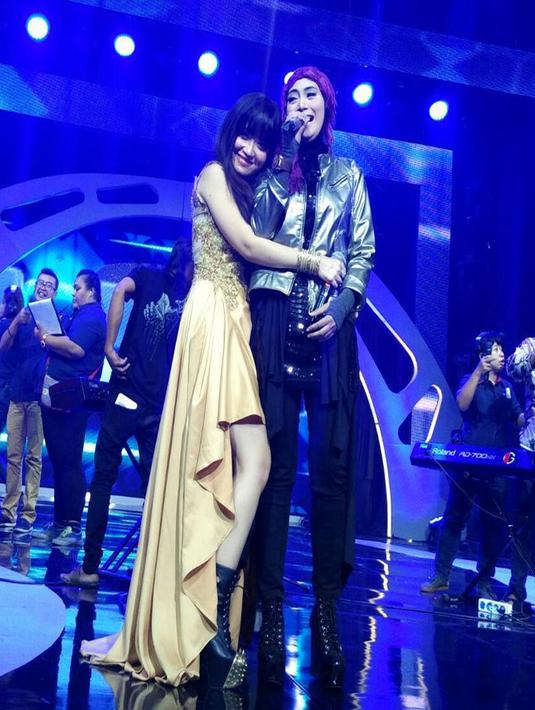 Tampil diatas panggung bersama Yuli KD, Lady Rock ini menggunakan jaket emas dengan paduan celana serta sepatu boots hitam menambah kesan rock dengan hijab simpel (Liputan6.com/Instagram/@inka_christie99)