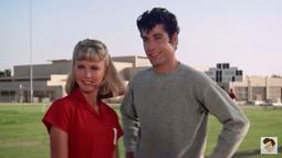 John Travolta alias Danny cemburu dengan kedekatan Olivia Newton John dengan lelaki lain. Saat berolahraga, Danny pun sampai terjatuh dan membuat Sandy panik. (Foto: YouTube)