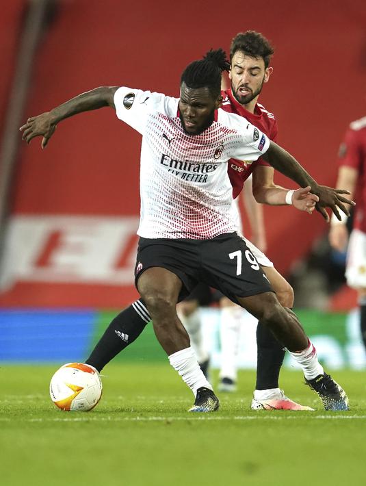 Gelandang AC Milan, Franck Kessie membawa bola dari kawalan gelandang Manchester United,  Bruno Fernandes pada pertandingan leg pertama babak 16 besar Liga Europa di Old Trafford, Inggris, Jumat (12/3/2021). MU bermain imbang atas AC Milan 1-1. (AP Photo/Dave Thompson)