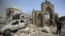 Anggota Counter Terrorism Service berdiri di samping Masjid Agung al-Nuri yang hancur diledakkan kelompok ISIS, di Kota Tua Mosul, 30 Juni 2017. Masjid yang mendapatkan julukan "si bungkuk" ini dikenal dengan menaranya yang miring. (AHMAD AL-RUBAYE/AFP)