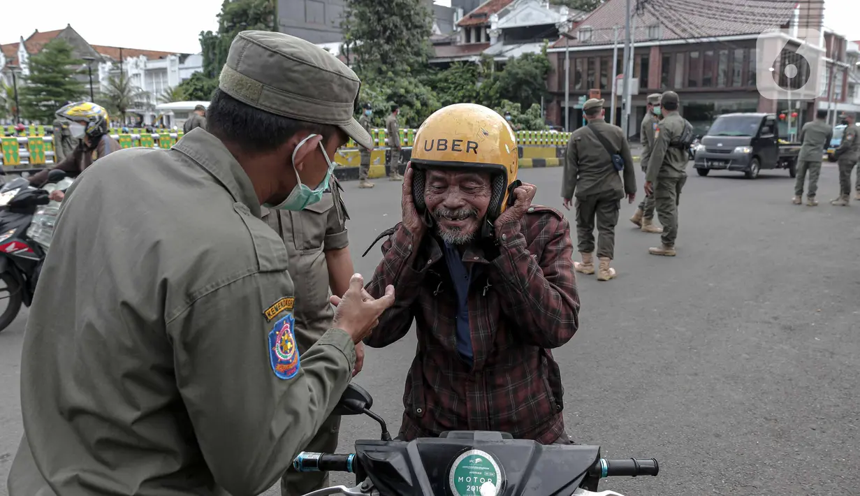 Petugas Satpol PP memberhentikan pengendara sepeda motor saat melakukan razia masker di kawasan Kota Tua, Jakarta, Kamis (24/2/2022). Pemerintah pusat kembali memperpanjang masa PPKM level 3 untuk wilayah Jakarta, Bogor, Depok, Tangerang dan Bekasi (Jabodetabek). (Liputan6.com/Faizal Fanani)