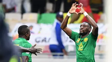 Pemain depan Kamerun Karl Toko Ekambi berselebrasi setelah mencetak gol ke gawang Gambia pada pertandingan perempatfinal Piala Afrika 2021 di Japoma Stadium, Minggu (30/1/2022) dini hari WIB. Kamerun melangkah ke semifinal usai menang atas Gambia, 2-0. (CHARLY TRIBALLEAU / AFP)