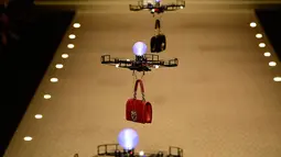Barisan pesawat tanpa awak (drone) membawa koleksi tas tangan Dolce & Gabbana pada Milan Fashion Week 2018, Minggu (25/). Bak model, deretan drone terbang berbaris rapi diiringi soundtrack 'Black Panther', 'All of the Stars'. (AP/Antonio Calanni)