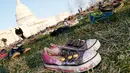 Ribuan sepatu menutupi halaman rumput di depan Gedung Capitol, Washington DC, Selasa (13/3). Sekitar 7000 ribu pasang sepatu dengan berbagai model diletakkan dan disusun secara trapesium. (Paul Morigi/AP Images for AVAAZ)