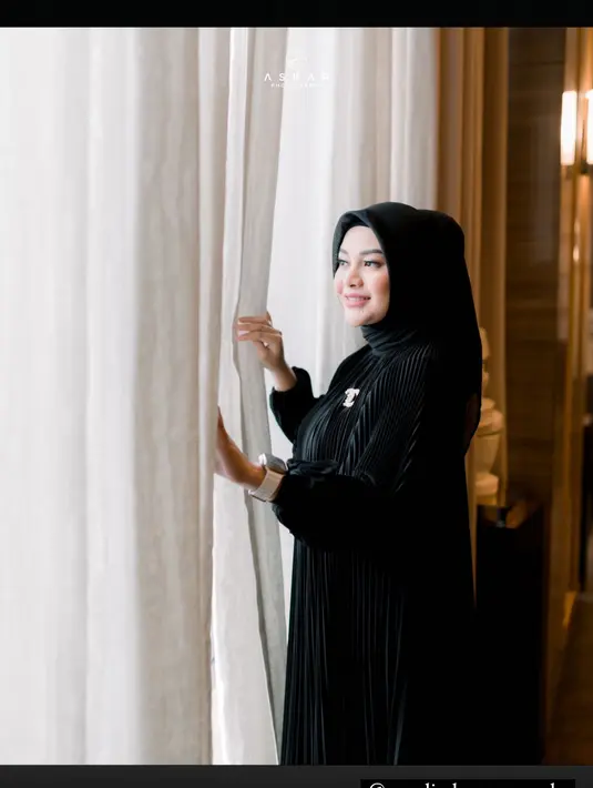 Aurelie Hermansyah nampak anggun dengan balutan busana pleated dress dan hijab hitam [@tomy.askar]