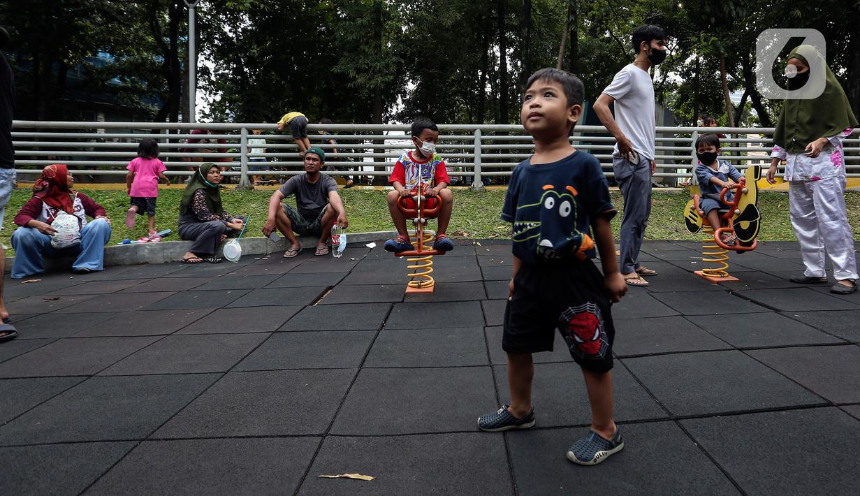 Anak-anak didampingi orang tua mereka bermain di Taman Puring, Jakarta, Minggu (9/1/2022). Di tengah ancaman penyebaran covid-19 varian Omicron dan pemberlakukan PPKM level 2, masyarakat tetap melakukan aktivitas pada akhir pekan di luar rumah. (Liputan6.com/Johan Tallo)