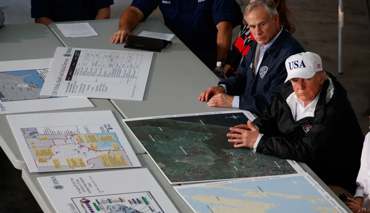 Presiden AS, Donald Trump dan Gubernur Texas Greg Abbot mendengarkan pengarahan terkait penanganan dan evakuasi warga terdampak Badai Harvey di Firehouse 5 in Corpus Christi, Selasa (29/8). Trump tiba di Texas ditemani Melania Trump. (AP Photo/Evan Vucci)