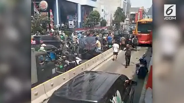 Sebuah mobil hancur menabrak separator busway setelah sempat menabrak motor. Video ini viral karena puluhan pengendara motor mengepung mobil tersebut.