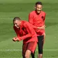 Pemain Paris Saint-Germain (PSG), Neymar (kanan) dan Kylian Mbappe (kiri) tertawa saat sesi latihan di Paris Barat, Prancis, Senin (17/9). PSG akan menghadapi Liverpool di Liga Champions pada 19 September 2018. (Anne-Christine POUJOULAT/AFP)