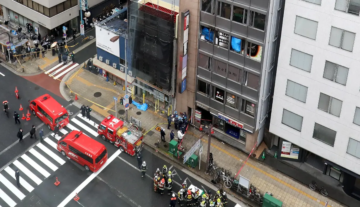 Mobil pemadam kebakaran terlihat di depan sebuah gedung, tempat kebakaran terjadi di Osaka (17/12/2021). Polisi masih menyelidiki penyebab kebakaran lantai empat di bangunan berlantai delapan tersebut. (AFP/STR/Jiji Pers)